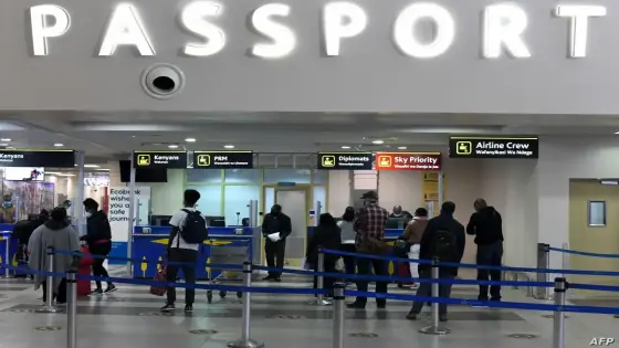 Passengers, wearing protective face masks, queue at passport control desks at the Jomo Kenyatta international airport in Nairobi, on August 1, 2020, as Kenya Airways airline resumed flights to Britain after flights had been cancelled during the COVID-19 (novel coronavirus) pandemic outbreak. (Photo by Simon MAINA / AFP)