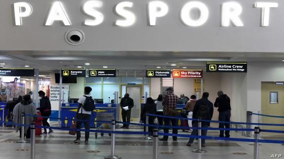Passengers, wearing protective face masks, queue at passport control desks at the Jomo Kenyatta international airport in Nairobi, on August 1, 2020, as Kenya Airways airline resumed flights to Britain after flights had been cancelled during the COVID-19 (novel coronavirus) pandemic outbreak. (Photo by Simon MAINA / AFP)